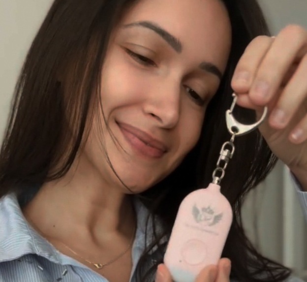 The pink SuperQueen safety alarm held on its keyring